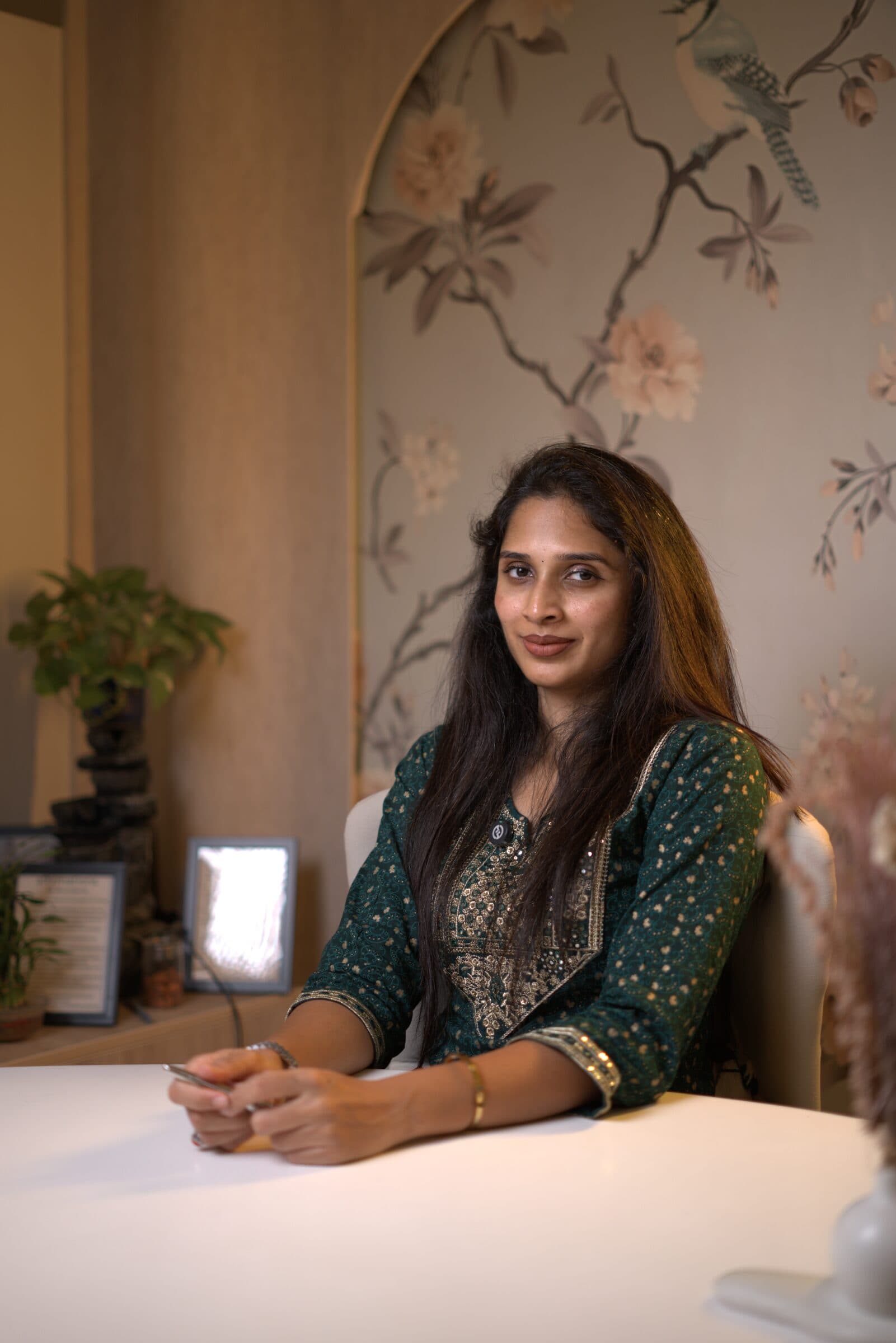 A pregnant woman in a softly lit, warm interior.