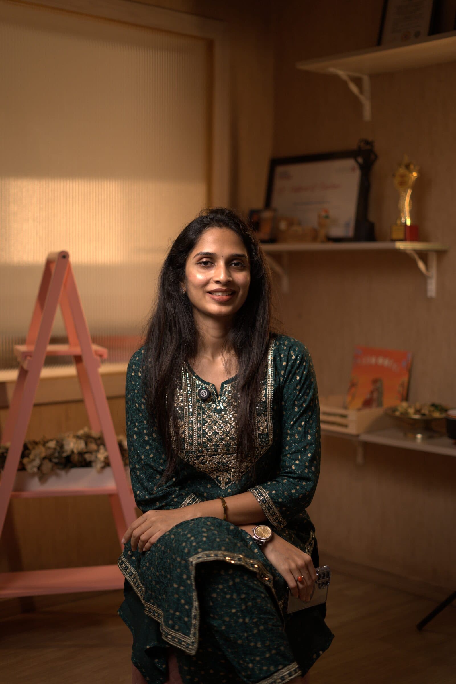 An expectant mother peacefully looking out a sunlit window beside soft linen curtains.